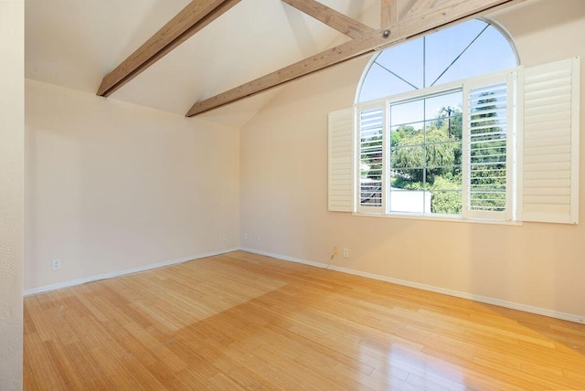 empty room featuring vaulted ceiling with beams, wood finished floors, and baseboards