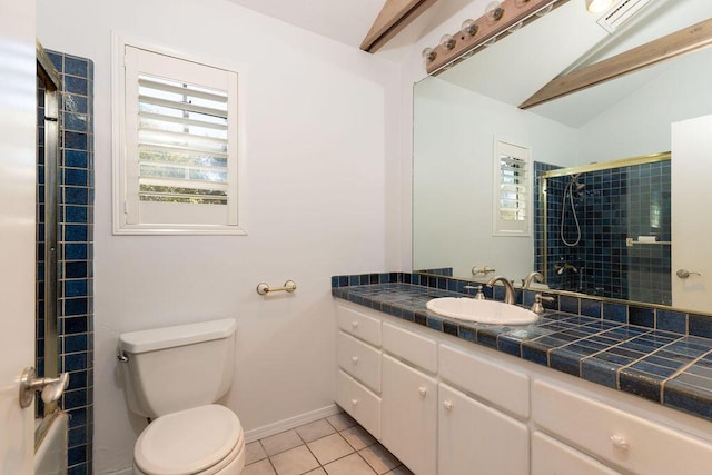 bathroom with tile patterned floors, toilet, lofted ceiling, tiled shower, and vanity