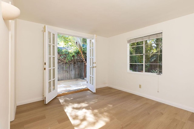 interior space with french doors, baseboards, and wood finished floors