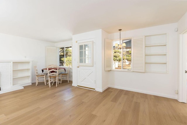 dining room featuring a notable chandelier, baseboards, and light wood-style floors