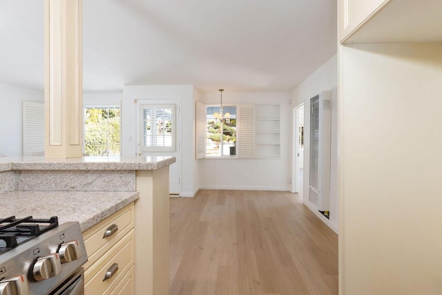 kitchen with light stone counters, plenty of natural light, light wood-style flooring, and baseboards