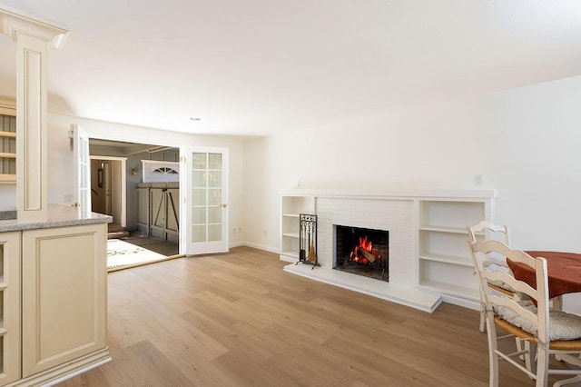 unfurnished living room with a brick fireplace and light wood-type flooring