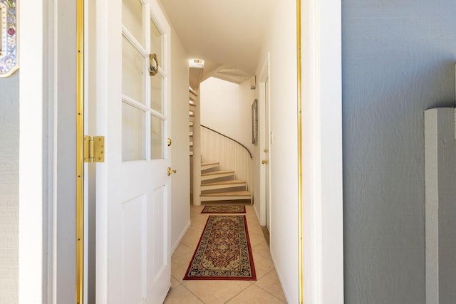 corridor with stairs and light tile patterned floors