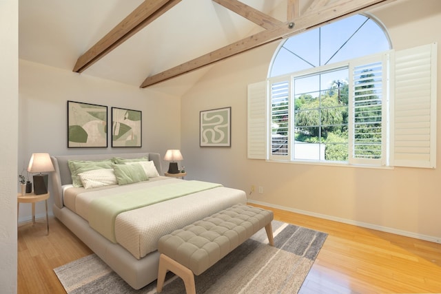 bedroom with lofted ceiling with beams, wood finished floors, and baseboards