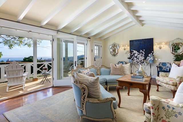 living area with lofted ceiling with beams, plenty of natural light, and wood finished floors