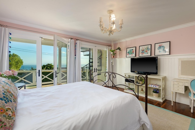 bedroom featuring wood finished floors, a wainscoted wall, an inviting chandelier, ornamental molding, and access to outside