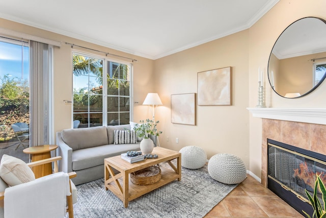 living room featuring a tiled fireplace, crown molding, and light tile patterned flooring