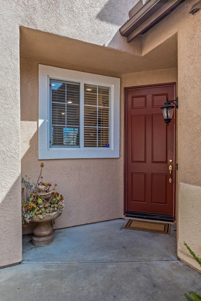 entrance to property featuring stucco siding