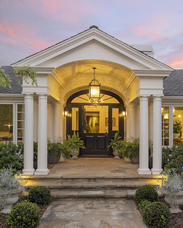 property entrance with stucco siding and a porch