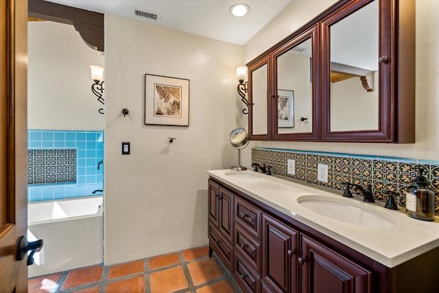 bathroom featuring visible vents, double vanity, a sink, a bathtub, and backsplash