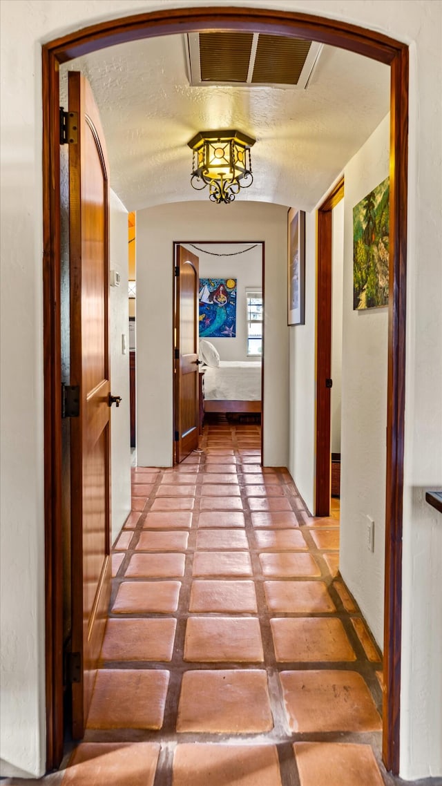 hall with visible vents and lofted ceiling