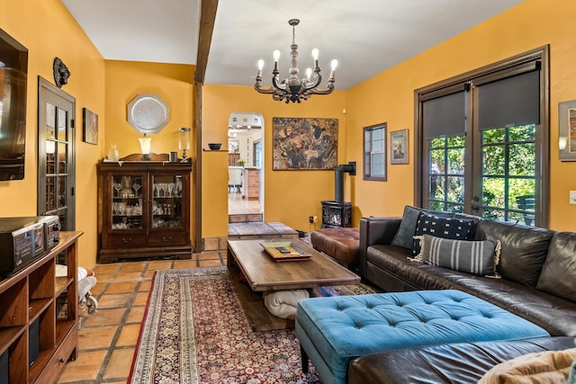 living room with french doors, a chandelier, and a wood stove