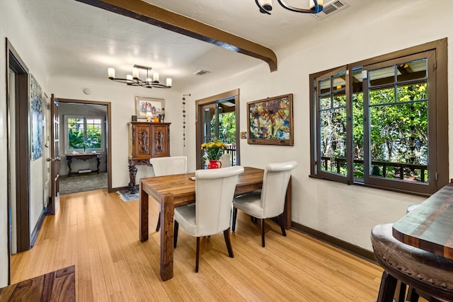 dining area with visible vents, beamed ceiling, a notable chandelier, light wood-style floors, and baseboards