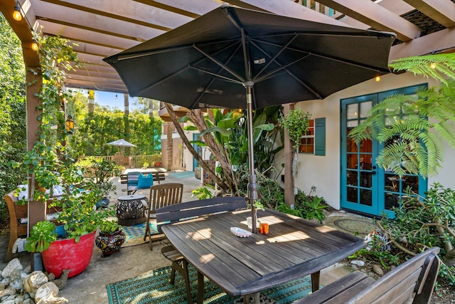 view of patio featuring outdoor dining space, french doors, and a pergola