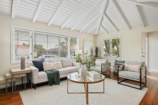 living room featuring lofted ceiling with beams, baseboards, and hardwood / wood-style floors