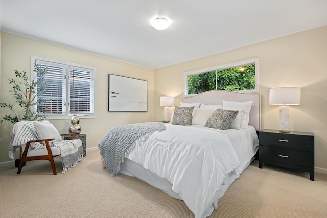 bedroom with multiple windows, light colored carpet, and baseboards