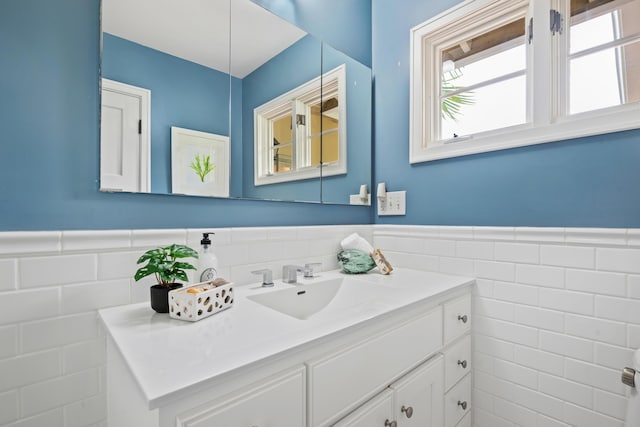 bathroom featuring vanity, tile walls, and wainscoting