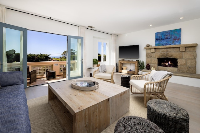 living room with visible vents, recessed lighting, a fireplace, and wood finished floors