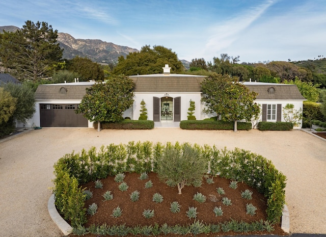 view of property with a mountain view, french doors, a garage, and driveway