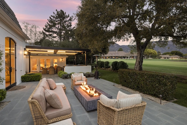 view of patio / terrace featuring french doors and an outdoor living space with a fire pit