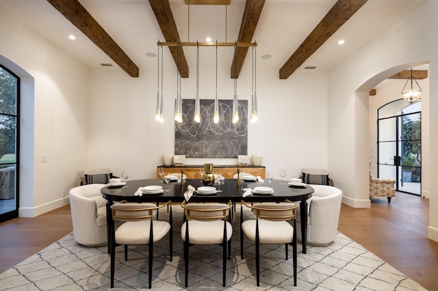 dining space with plenty of natural light, arched walkways, baseboards, and light wood finished floors