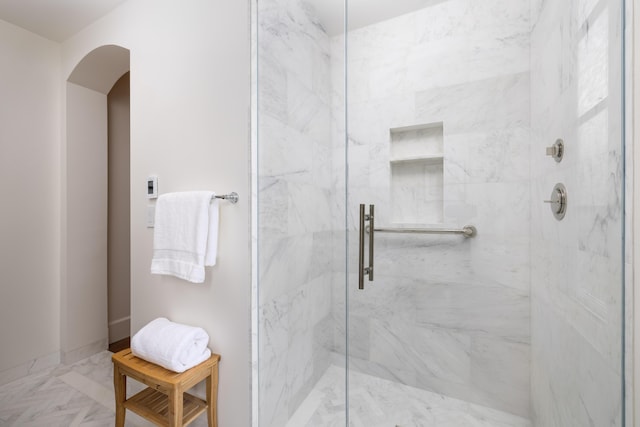 full bath with baseboards and a marble finish shower