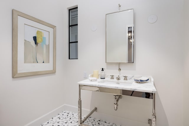 bathroom with a sink and baseboards