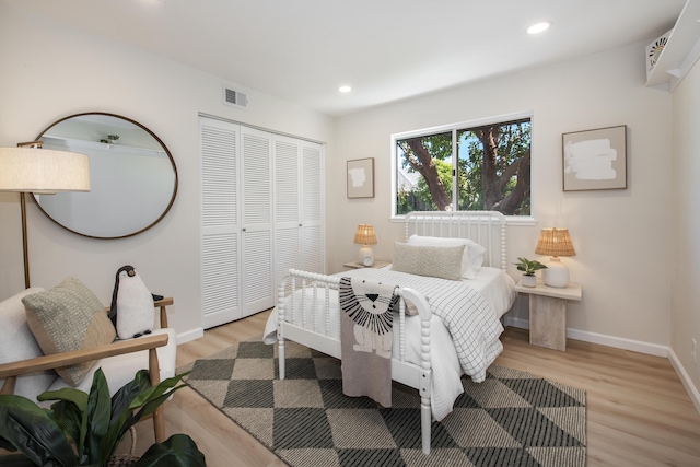 bedroom with light wood-type flooring, visible vents, a closet, and recessed lighting