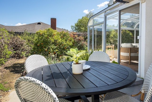 exterior space with outdoor dining area and a sunroom