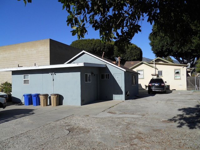 view of side of home with fence and stucco siding