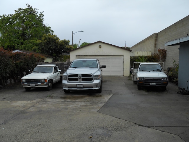 view of property exterior with stucco siding, a detached garage, and an outdoor structure