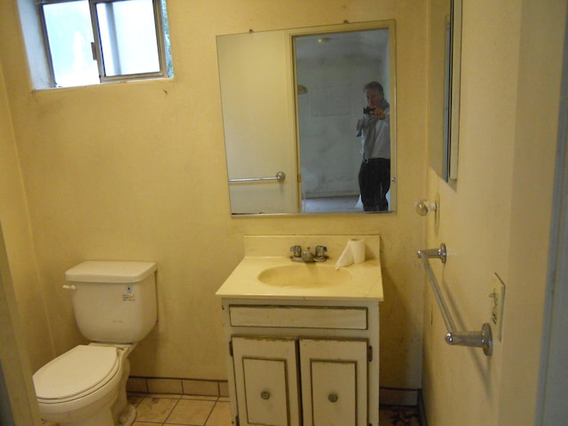 bathroom featuring vanity, tile patterned floors, toilet, and baseboards