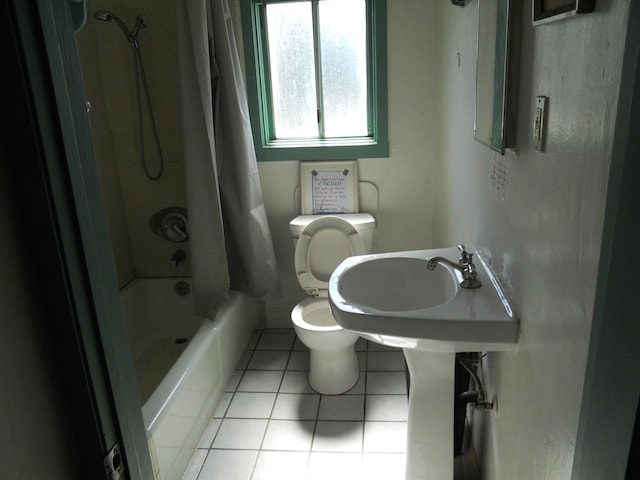 bathroom featuring tile patterned floors, shower / tub combo, toilet, and a sink