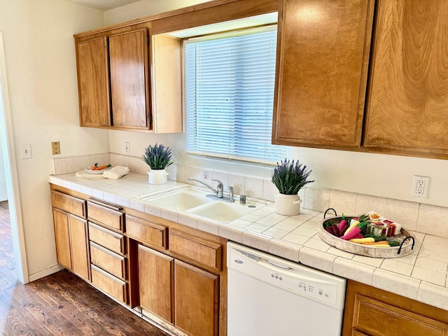 kitchen featuring brown cabinets, a sink, dark wood-style floors, light countertops, and dishwasher