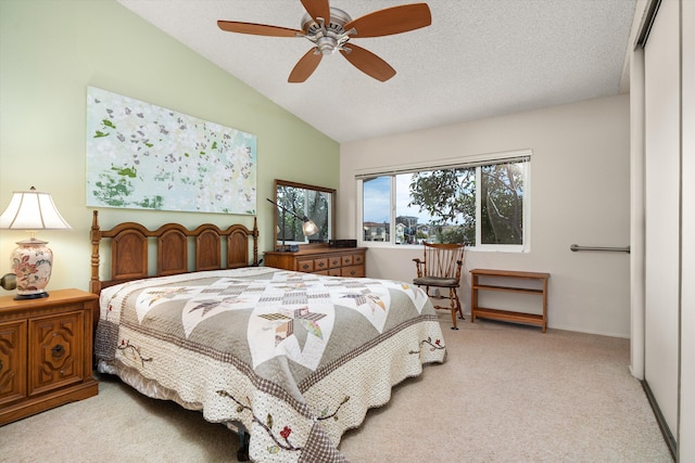 carpeted bedroom with lofted ceiling, a textured ceiling, and a ceiling fan