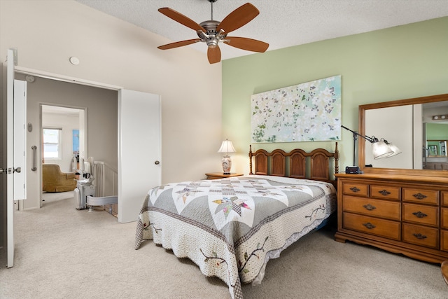 bedroom featuring a ceiling fan, light colored carpet, and a textured ceiling