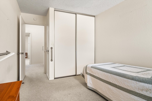 bedroom featuring a closet, carpet floors, and a textured ceiling