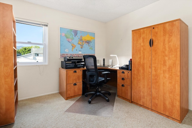 home office with light colored carpet, a textured ceiling, and baseboards