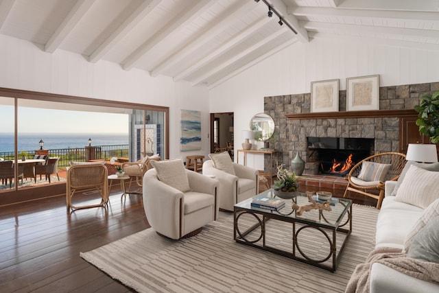 living area featuring high vaulted ceiling, beam ceiling, a stone fireplace, a water view, and wood-type flooring