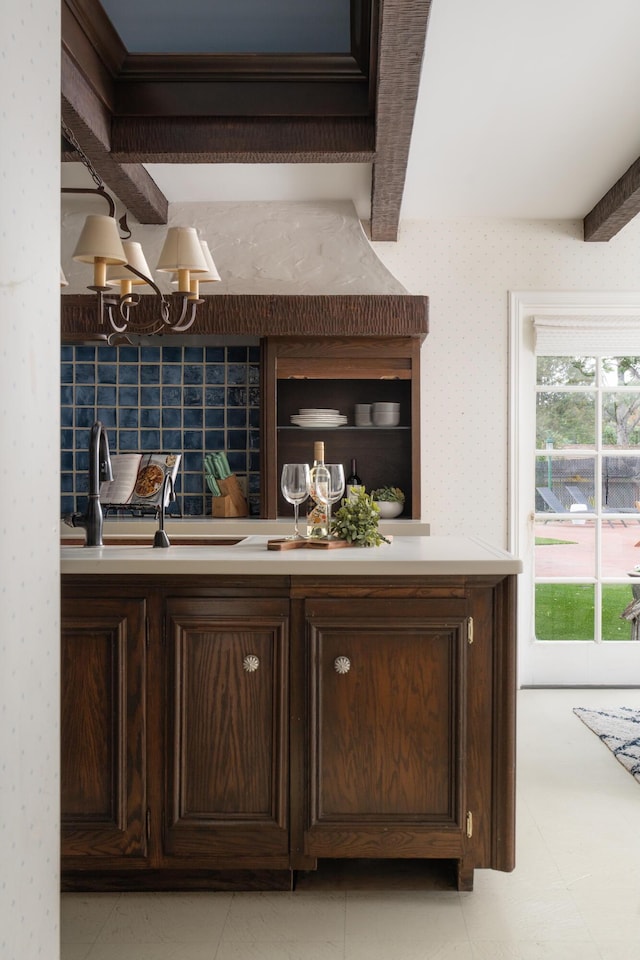 bar featuring wallpapered walls, beam ceiling, an inviting chandelier, and a sink