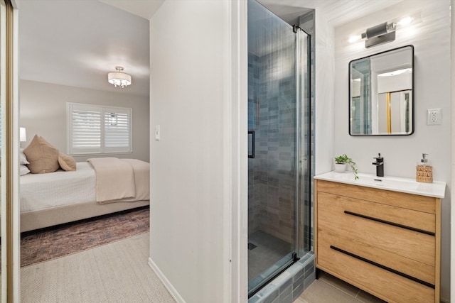 ensuite bathroom with a shower stall, ensuite bath, vanity, and baseboards