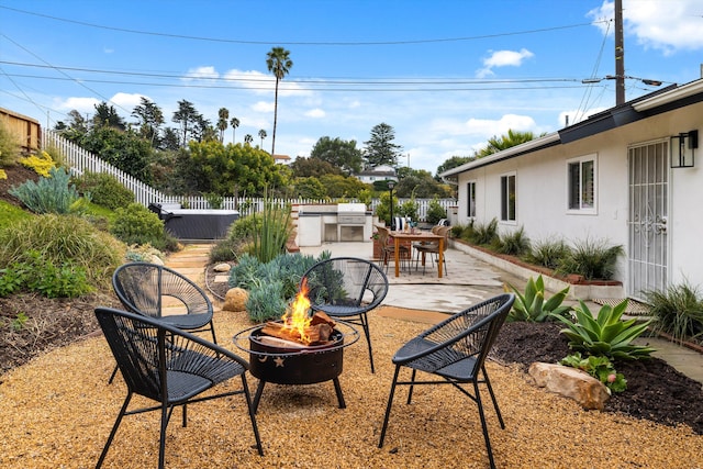 view of patio featuring area for grilling, fence, and an outdoor fire pit