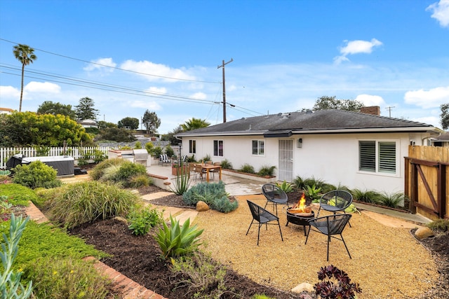 back of property with a fire pit, fence, central AC, stucco siding, and a patio