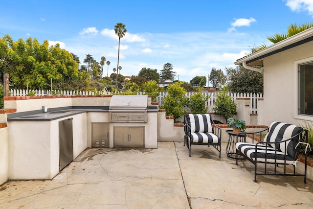 view of patio featuring area for grilling, outdoor dining area, fence, and a grill