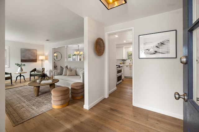 foyer with visible vents, a notable chandelier, wood finished floors, and baseboards