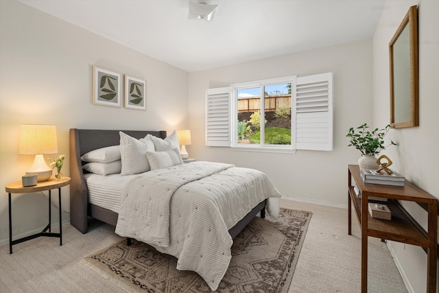 bedroom with light colored carpet and baseboards