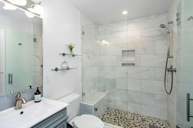 bathroom featuring tasteful backsplash, toilet, a stall shower, and vanity