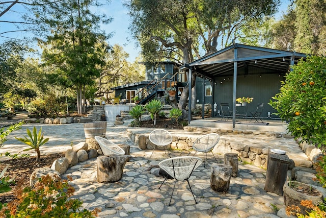 view of patio featuring a gazebo, stairs, and an outdoor fire pit