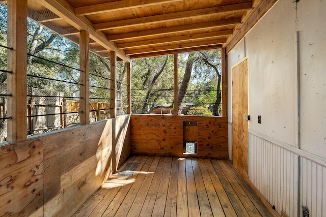 unfurnished sunroom featuring beamed ceiling and wood ceiling