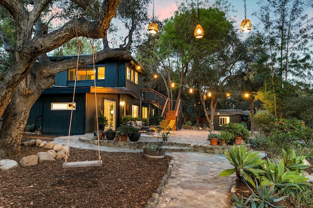 rear view of property featuring a patio area and stairway